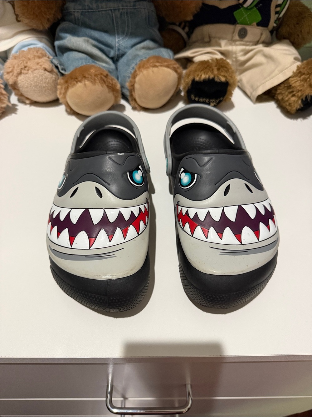 Crocs-style clogs with a shark and lightning design.